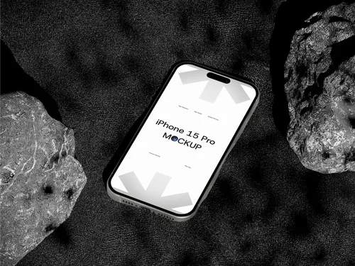 iPhone Pro on rock, top view, against sandy background