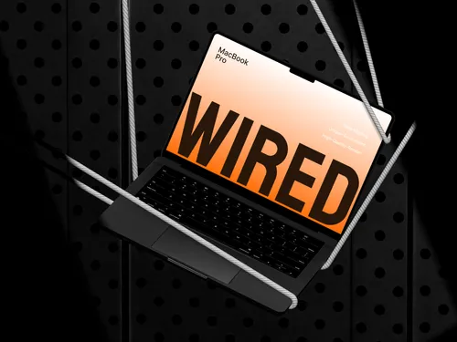 MacBook Pro tilted left, connected to wires and cables.